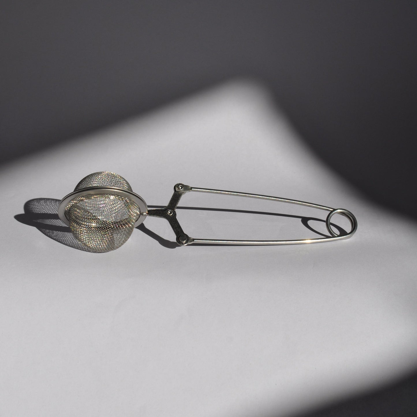 Metallic tea infuser on a dark background