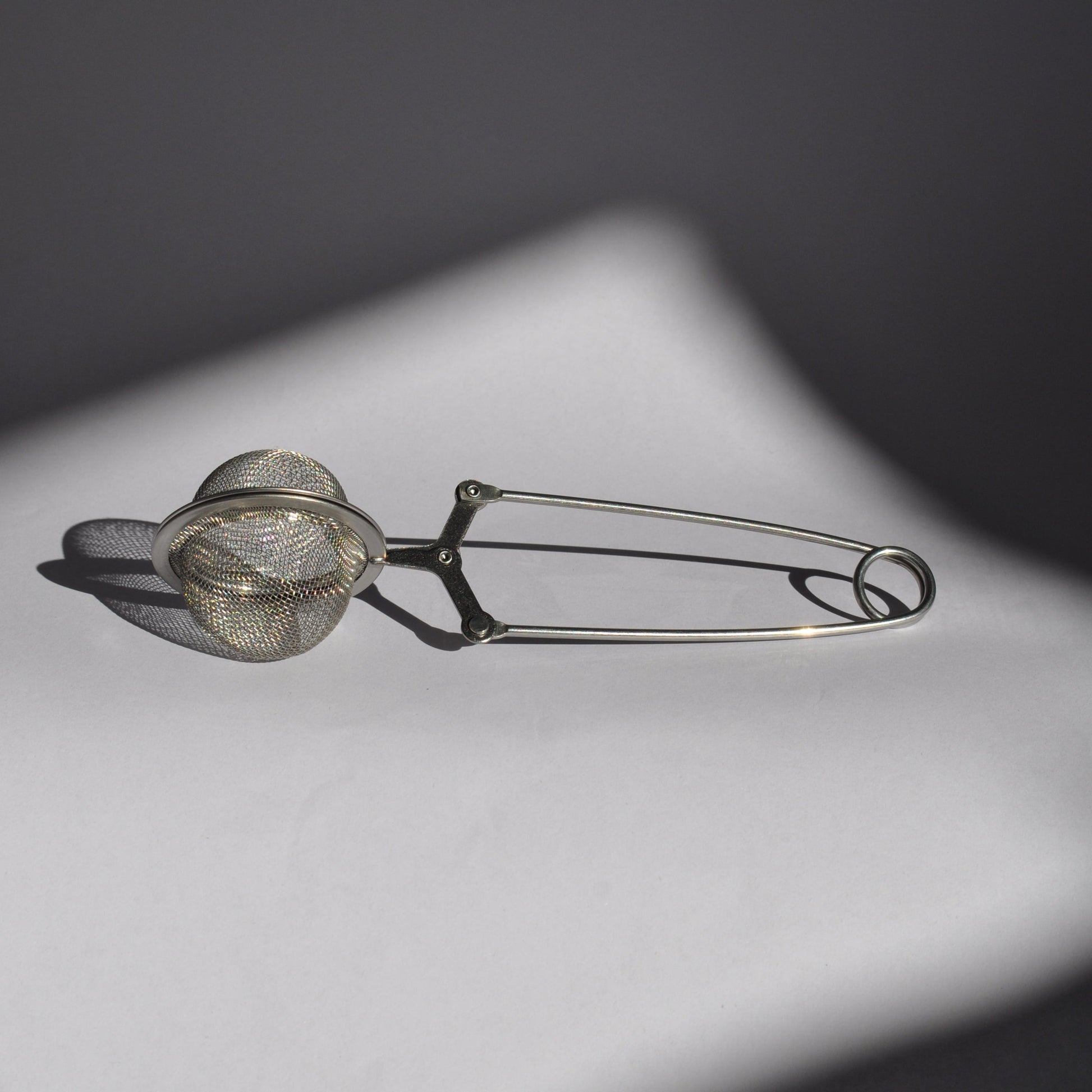 Metallic tea infuser on a dark background